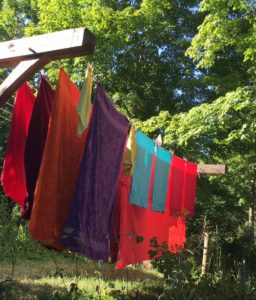 Colorful laundry on a sunny day, hanging on a clothesline near the home.